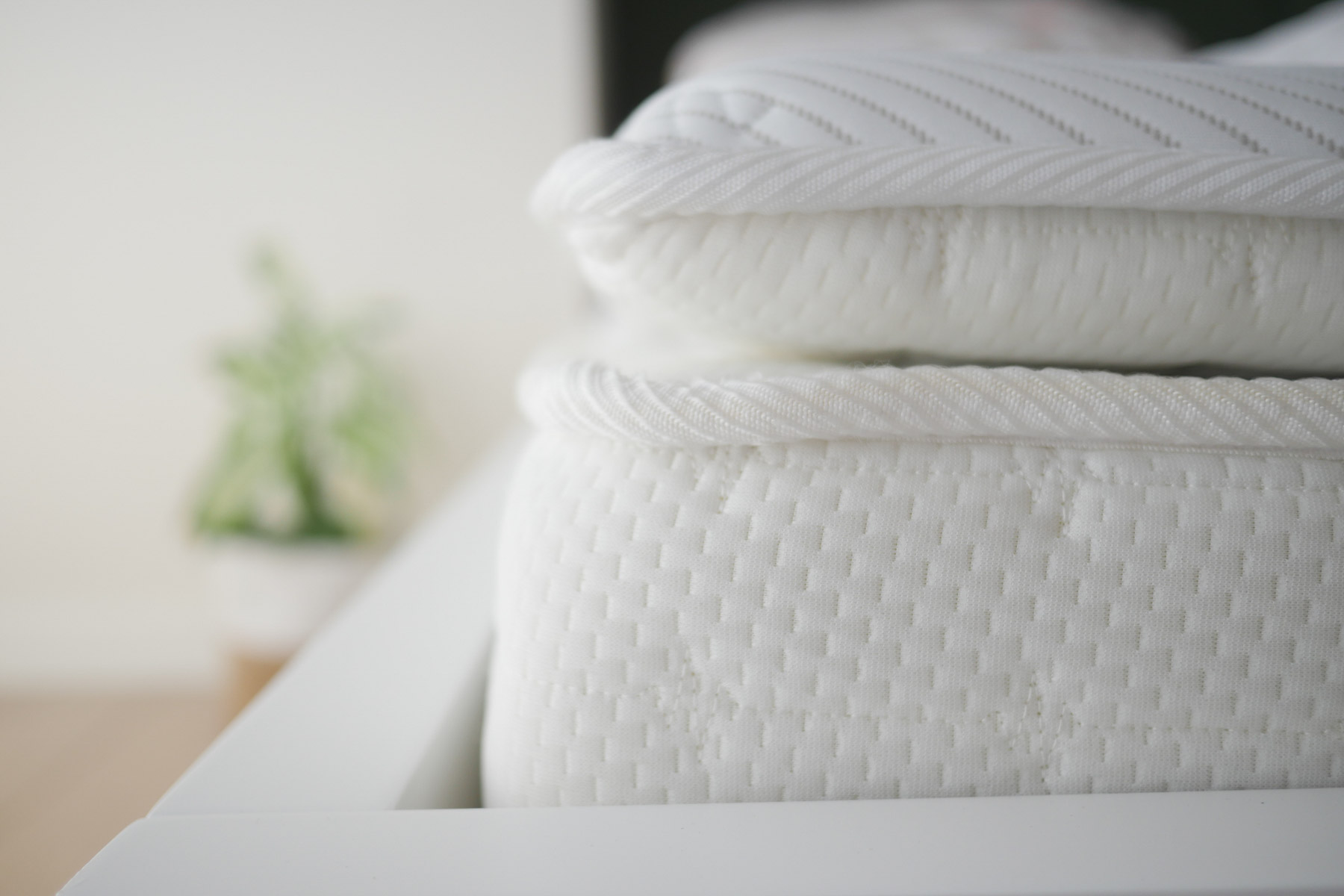 Cozy White Bedding Stacked On A Modern Bed Frame In A Bright Room